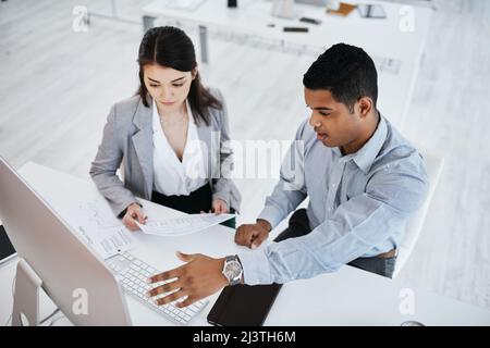 The companys top performance boosters. Shot of a young businessman and businesswoman using a computer in a modern office. Stock Photo