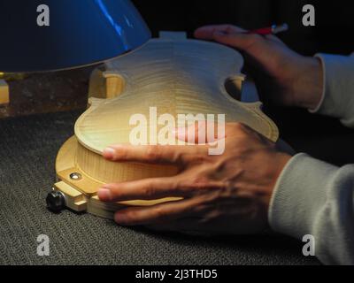 luthier working on a new violin in his workshop Stock Photo
