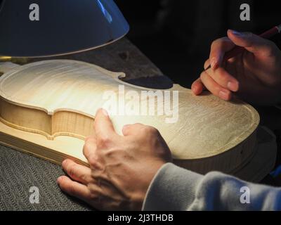luthier working on a new violin in his workshop Stock Photo