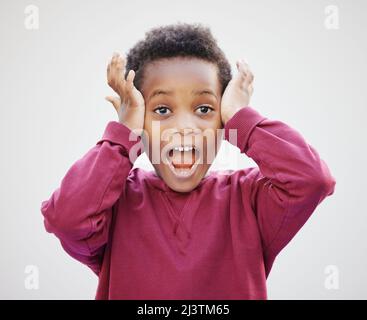 Its a crazy toy sale. Shot of an adorable little boy standing against a white background. Stock Photo