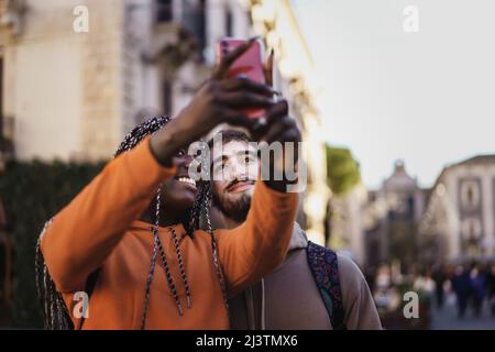 Couple of biracial young people visiting an European city and taking selfie together Stock Photo