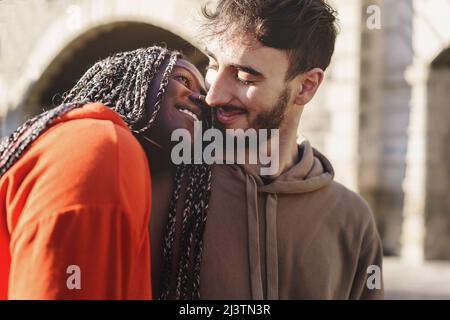 Engaged multiethnic couple hugging and walking together in the city Stock Photo