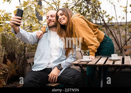 Couple of young people taking selfies in the terrace Stock Photo
