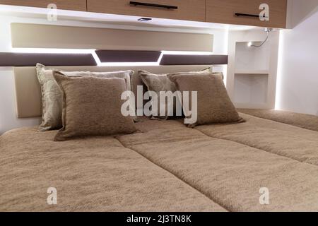 closeup of bed and pillows inside empty bedroom in luxury RV camper trailer interior Stock Photo