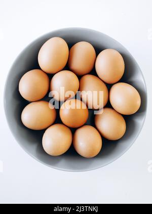 White eggs on a grey plate and a white background Stock Photo
