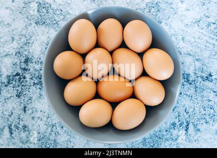White eggs on a grey plate and a blue background Stock Photo