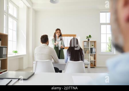 Teacher asking one of her adult students a question during a discussion in class Stock Photo