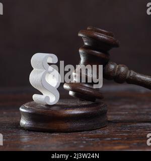 Wooden judges gavel and symbol of law and justice on table in a courtroom or law enforcement office on dark background Stock Photo