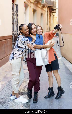 Cheerful diverse ladies taking selfie portrait in town Stock Photo