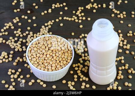 Bottle of Soy Milk Isolated on Black Wooden Table with Scattered Soy Beans Stock Photo
