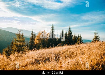 A beautiful horizontal shot of the rising sun and high mountains under the cloudy sky Stock Photo