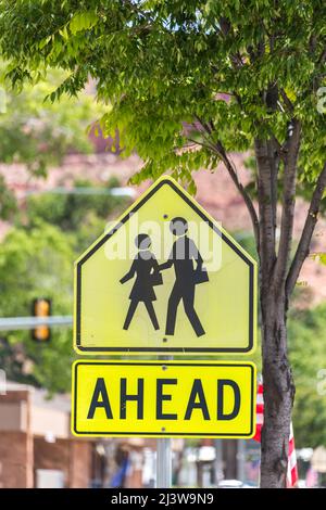 Crosswalk Sign Against green trees in small american town Stock Photo