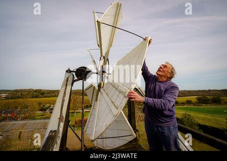 Volunteers check the fantail atop Wilton windmill, Wiltshire, where members of the Wilton Windmill Society are helping to complete the annual Spring clean of the traditional tower mill with fantail, built in 1871 and operational for 100 years. Picture date: Sunday April 10, 2022. Stock Photo