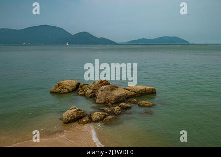 The view of beach with rocks during morning at Damai Laut Beach in Lumut, Malaysia. Stock Photo