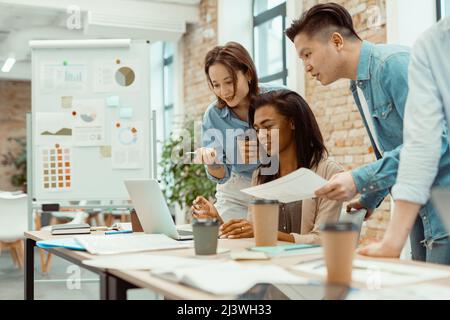 Young freelancers planning work on laptop together Stock Photo