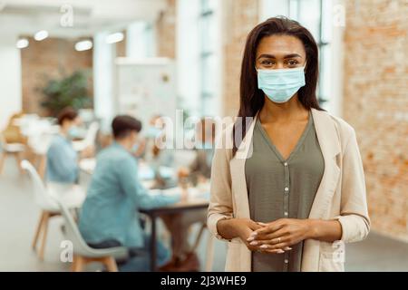 Lady wearing a protective mask while working in the office Stock Photo