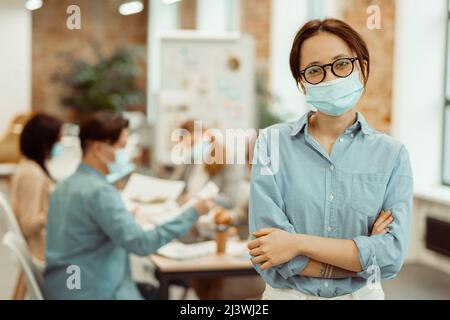Woman wearing a protective mask while working in the office Stock Photo