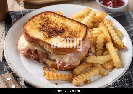 Grilled ham and cheese sandwich and french fries on a plate Stock Photo