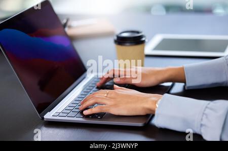 Working on her latest project. Cropped shot of an unrecognizable businesswoman working on her laptop in the office. Stock Photo