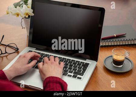 Blank laptop computer screen, Woman work at home office, open notebook on wooden table, black empty display, copy space, Stock Photo
