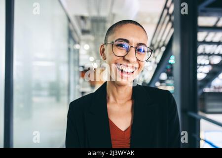 Successful young businesswoman smiling cheerfully. Happy young businesswoman standing alone in a modern workplace. Successful young businesswoman work Stock Photo