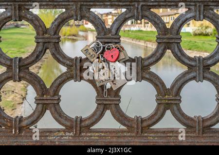 Padlocks with promises of love on the railing of the Verdi bridge, Parma, Italy Stock Photo