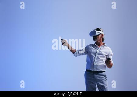 Mature businessman doing a presentation in the metaverse. Senior businessman leading a virtual meeting with his team. businessman working with his col Stock Photo
