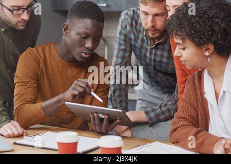 colleagues using a digital tablet during a work meeting . Stock Photo