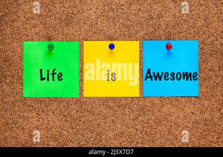 Three colored notes on a corkboard with words Life is Awesome. Stock Photo