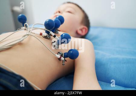 Little boy undergoing electrocardiogram test in clinic Stock Photo