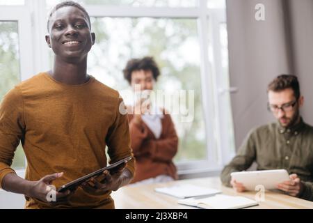 smiling young employee with a digital tablet . Stock Photo