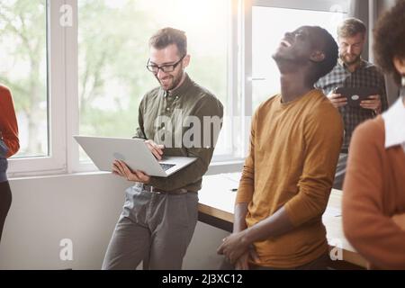 cheerful young employees standing near a table in a coworking ce Stock Photo