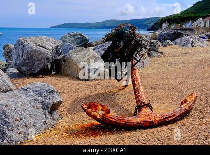 An old rusty anchor on the pebbled beach at Beesands Stock Photo