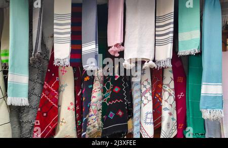 Row of elegant scarves hanging from a market display. Stock Photo