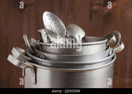 Vintage aluminum kitchen utensils, pan, metal cooking pots, spoons, forks Stock Photo