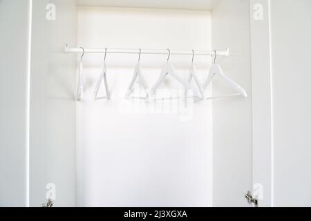 Real wood closet with white cloth hanger. Home bedroom background. Hotel wood style. Room backdrop. Modern interior. Apartment archicture. Simple living room decoration Stock Photo