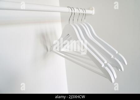 Real wood closet with white cloth hanger. Home bedroom background. Hotel wood style. Room backdrop. Modern interior. Apartment archicture. Simple living room decoration Stock Photo