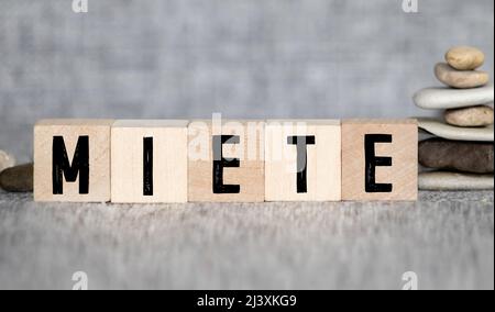 Symbol for rising rents. Dice form the German word Miete rent in English. A hand turns a dice and changes the direction of an arrow Stock Photo