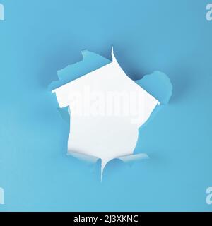 Abstract background of white hole in torn blue paper surface with copy space Stock Photo