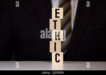 Wooden blocks with the word Ethic. Defending, systematizing and recommending concepts of right and wrong conduct. Moral philosophy Stock Photo