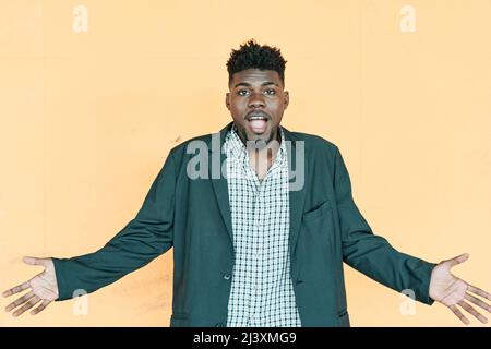 Doubtful African American man shrugging shoulders, feeling confused. Young hipster man with casual jacket looking at camera Stock Photo