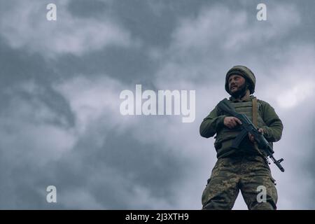Ukrainian soldier stands with kalashnikov assault rifle in his hands ...
