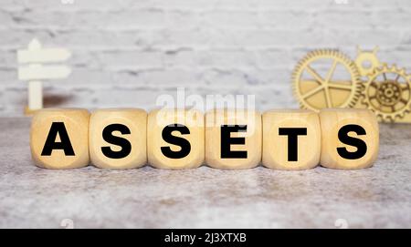 assets - word from wooden blocks with letters, useful or valuable thing assets concept, random letters around white background Stock Photo