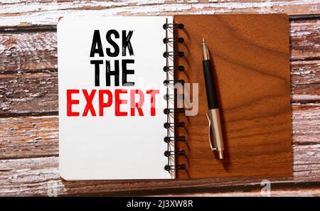 Ask the experts. Sticky note with ask the experts inscription pinned on a cork bulletin board Stock Photo