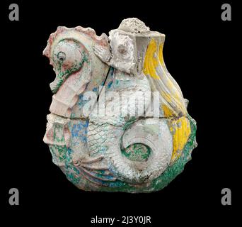 Dilapidated figure of a headless mermaid on a seahorse. A concrete sculpture with cracks and peeling, faded paint. A gloomy concrete statue for loss a Stock Photo