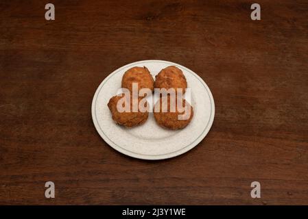 Delicious round croquettes of fresh cheese and ham tacos on a circular plate served in a Spanish tapas restaurant Stock Photo