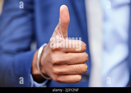 Positivity is the key. Shot of an unrecognizable businessman showing thumbs up. Stock Photo