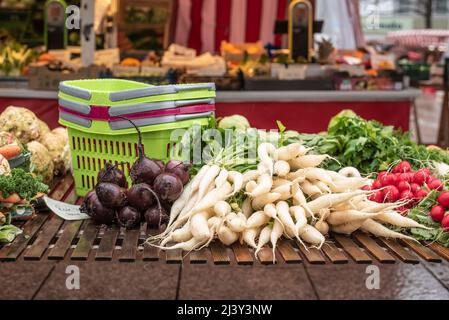 white and red radishes and beetroots on a wooden shelf at a market stall Stock Photo