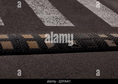 Traffic safety speed bump on an asphalt road.  Traffic calming device Stock Photo