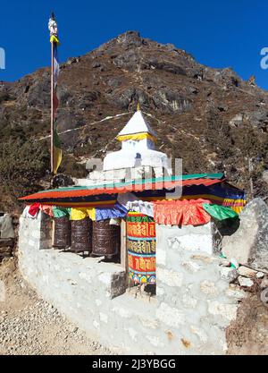 Buddhist stupa and prayer wheel in Thame village, Khumbu valley on three passes trek, Mount Everest area, Sagarmatha national park, Nepal Stock Photo